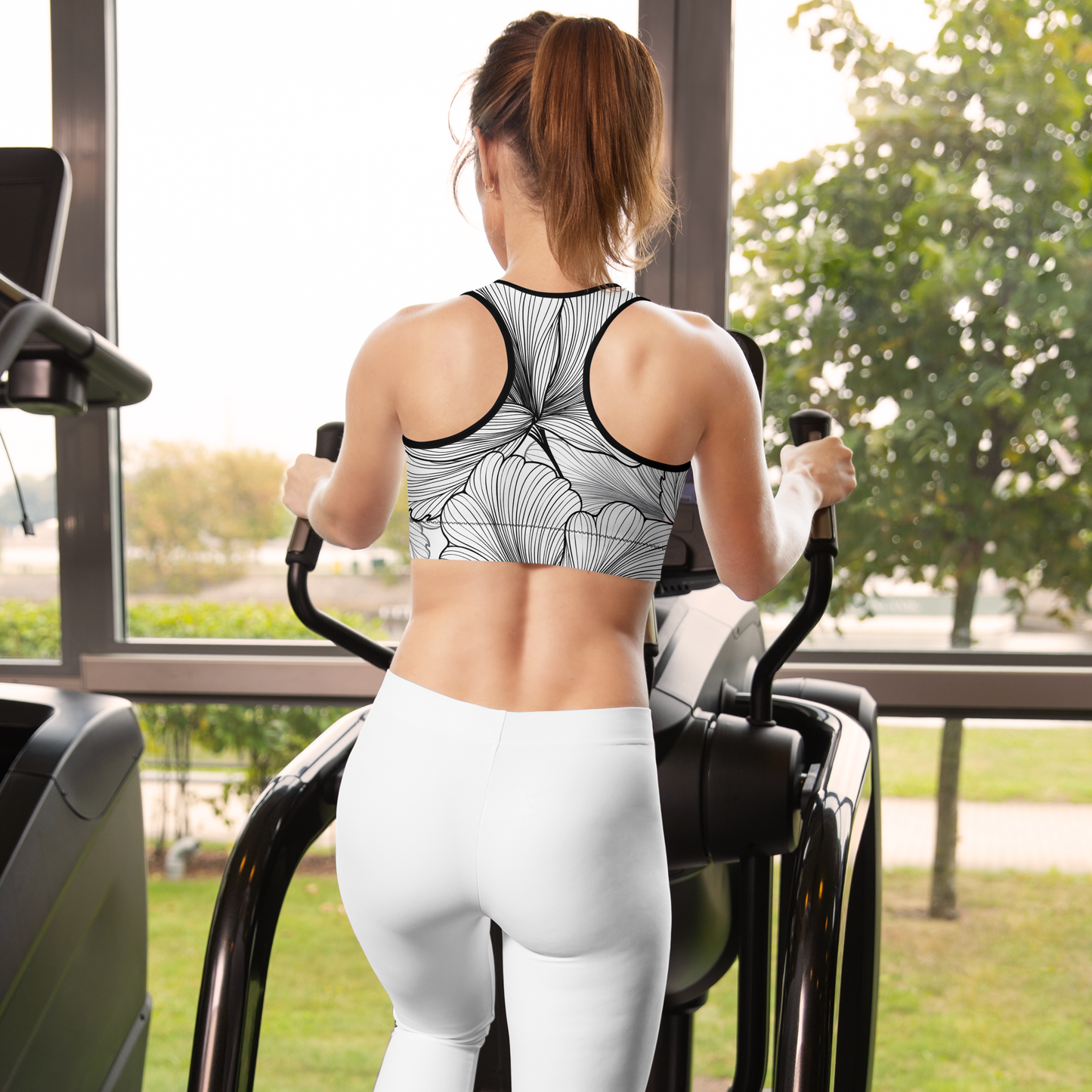 White sports bra with black outlined floral pattern and racerback design.