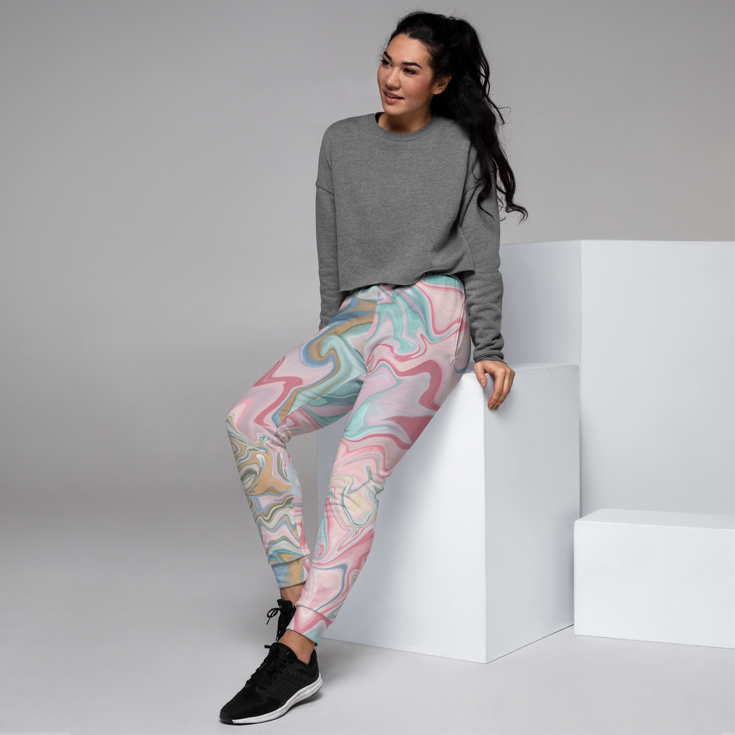Joggers feature swirling marble pattern in pastel pink, blue, and beige.