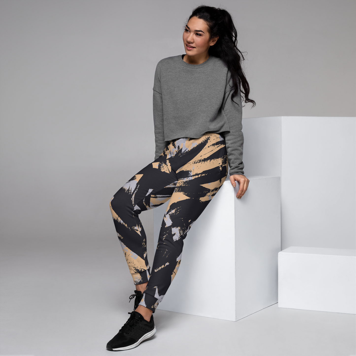 Women's joggers with black and beige abstract brush stroke design pattern.