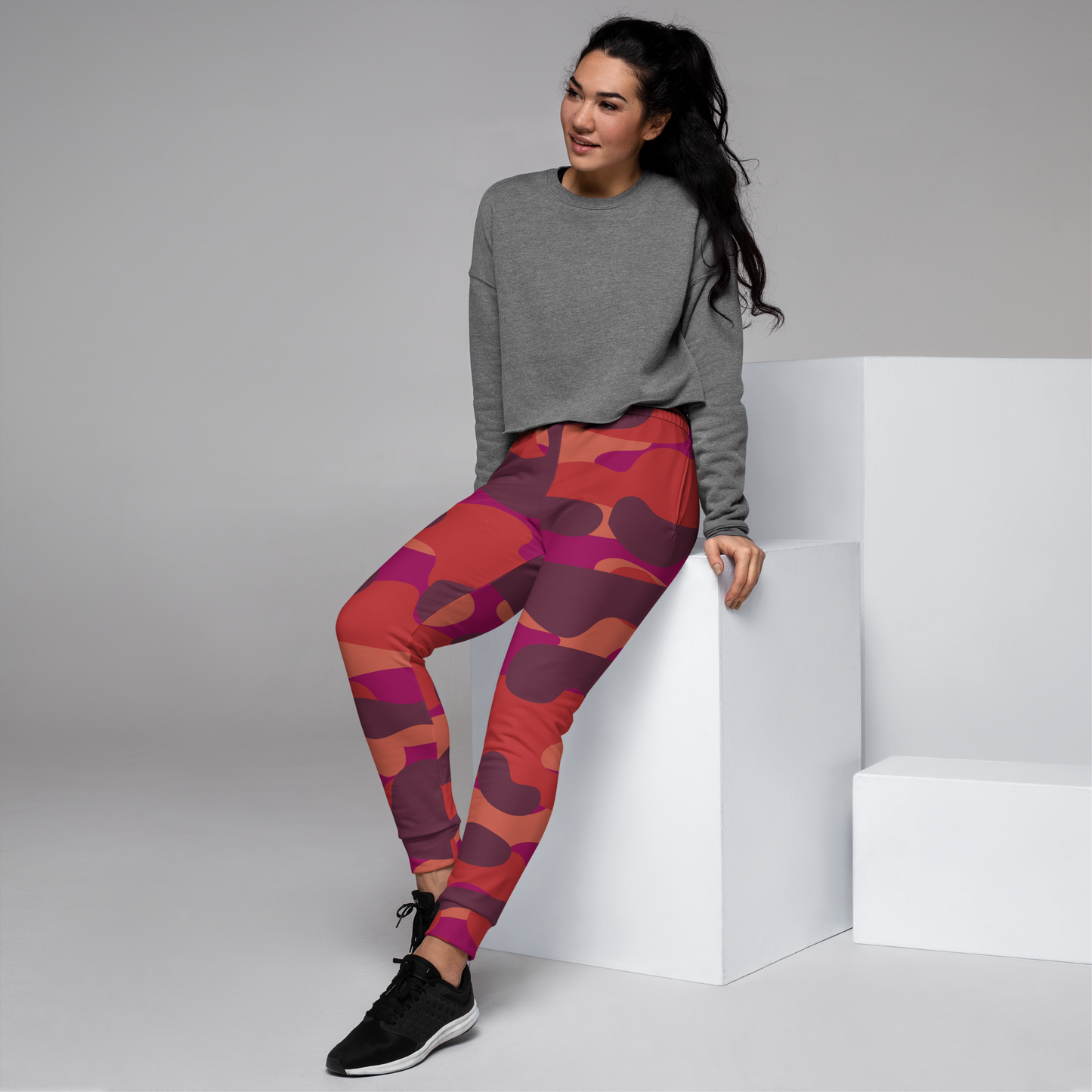 Women's joggers with abstract maroon, orange, and fuchsia pattern design.