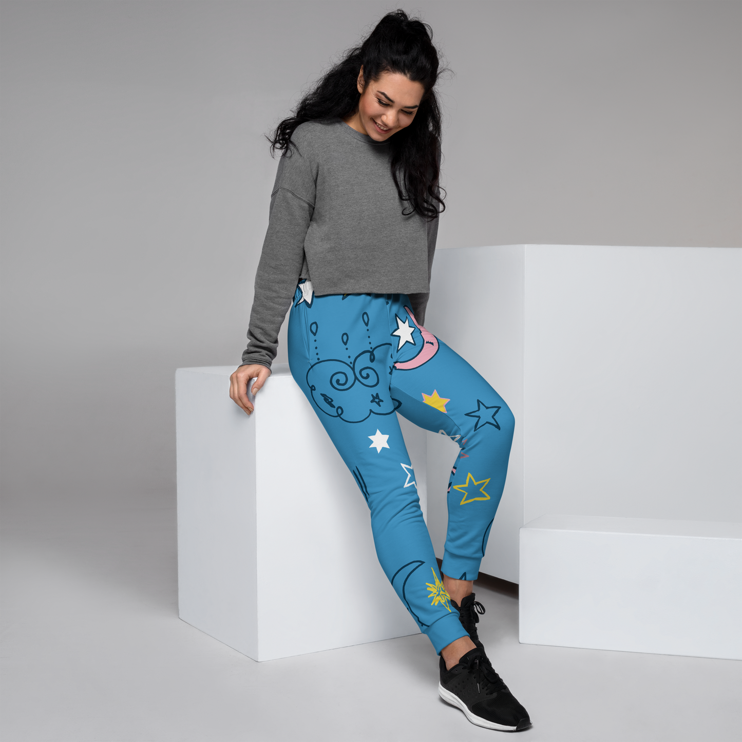 Blue joggers with playful cloud, moon and star doodle patterns.