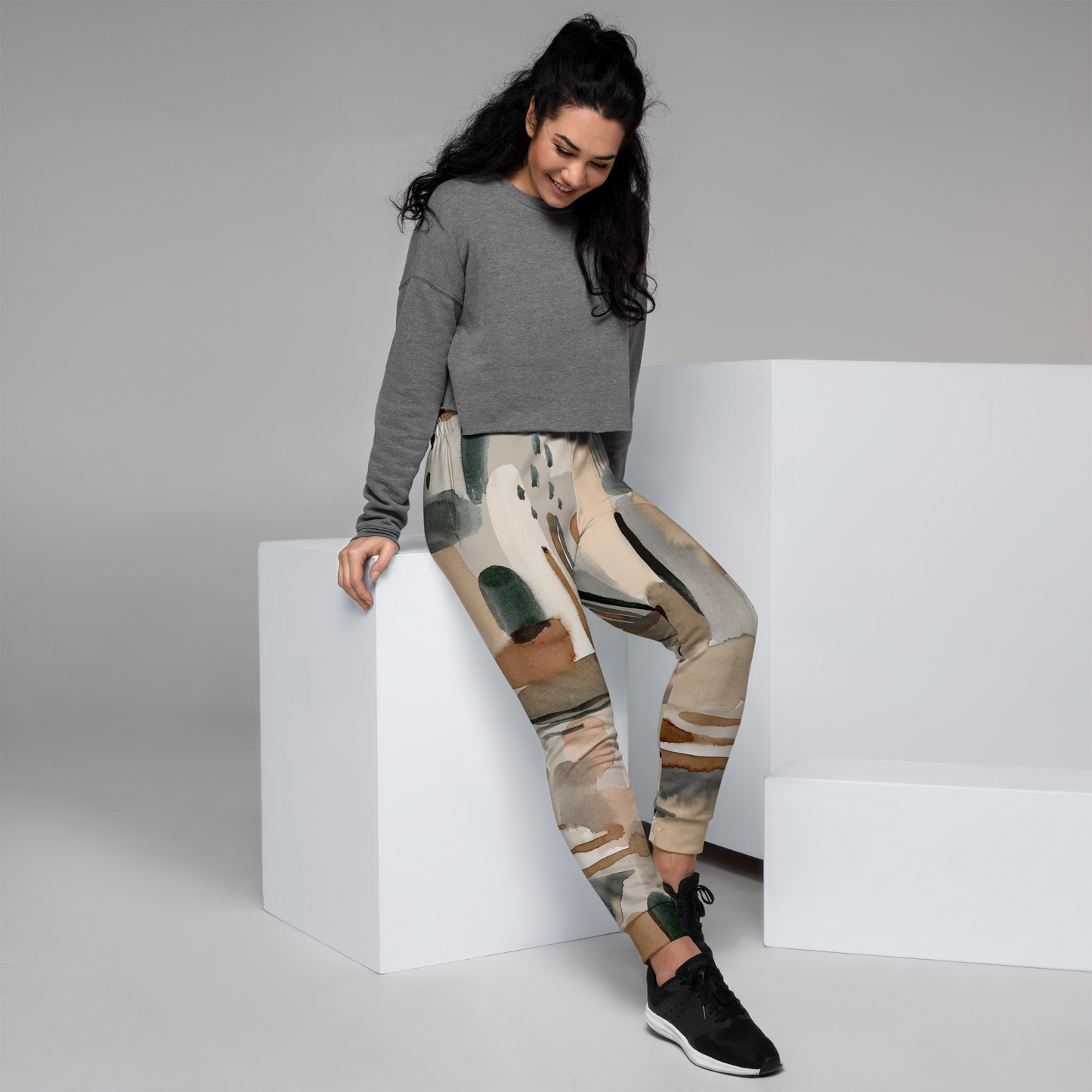 Women's joggers with beige, brown, and green abstract watercolor print.