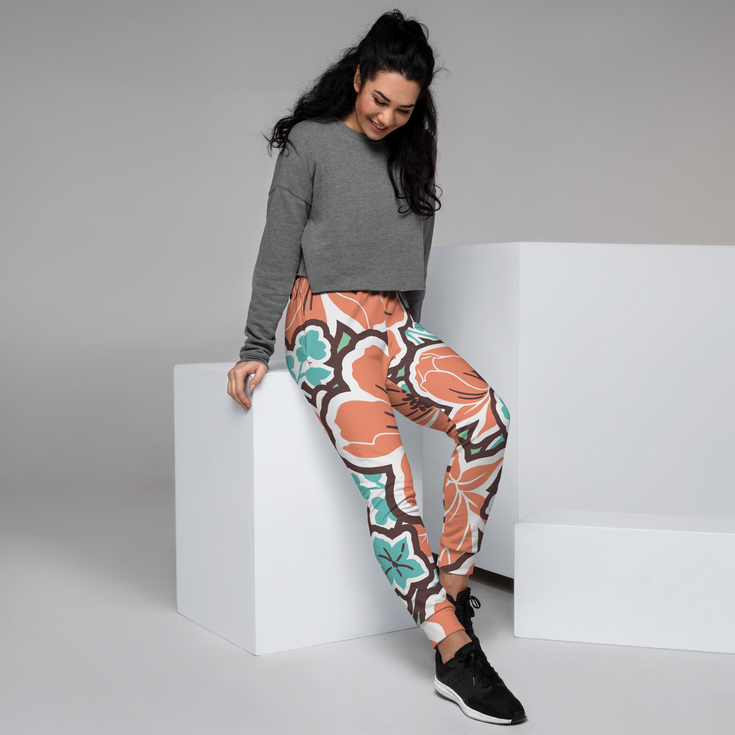Orange and teal floral print women's joggers with white accents.