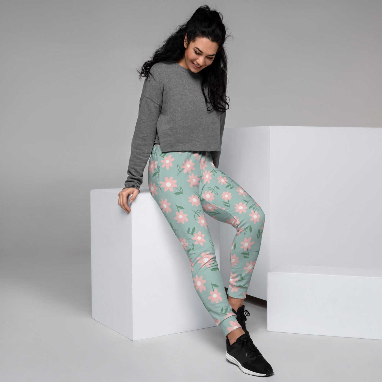 Women's joggers with pink daisy floral print on pale mint background.