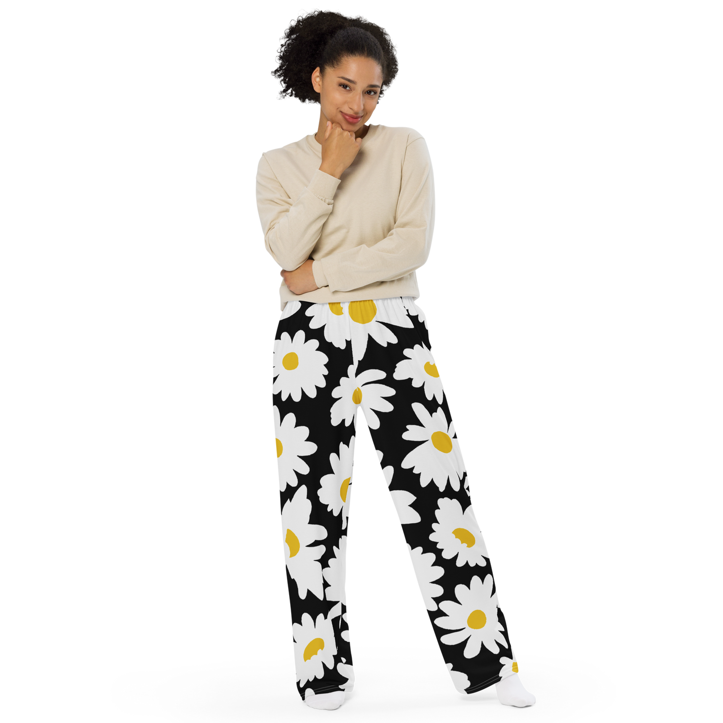 Wide-leg pants with oversized white daisies on a black background.